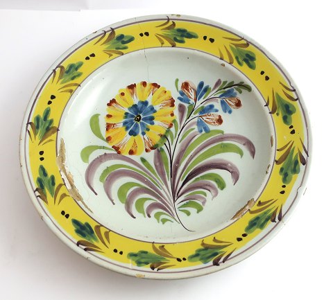 Kellinghusen-Teller, Fayence. Tiefer Teller mit Blumenmotiv. Durchmesser 23 cm. 
Mit Reparatur.