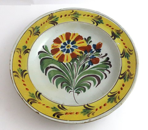 Kellinghusen-Teller, Fayence. Tiefer Teller mit Blumenmotiv. Durchmesser 23 cm. 
Mit Reparatur.