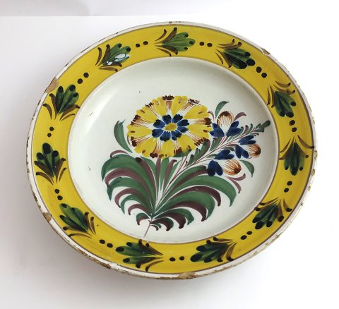 Kellinghusen-Teller, Fayence. Tiefer Teller mit Blumenmotiv. Durchmesser 23 cm. 
Mit Reparatur.